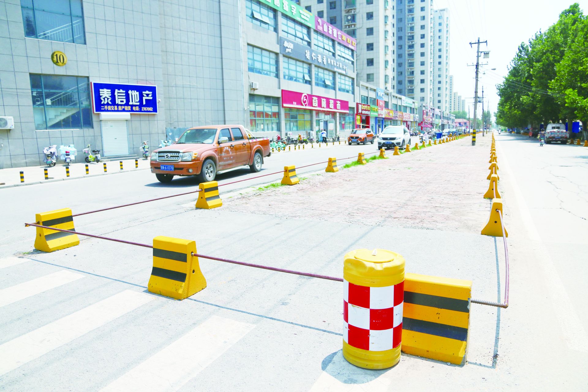 东七里铺便民市场出口道路设置隔离墩.记者路龙帅摄